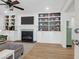 Inviting living room with custom built-ins, a decorative fireplace, ceiling fan, and hardwood floors at 1637 Pinckney Park Dr, Charleston, SC 29407