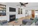 Open-concept living room featuring a fireplace, custom built-ins, a ceiling fan, and hardwood floors at 1637 Pinckney Park Dr, Charleston, SC 29407
