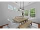 Bright dining area with a wooden table, modern light fixture, and lots of windows at 1726 Waterbrook Dr, Charleston, SC 29414