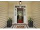 Inviting entryway with decorative plants flanking a front door with glass sidelights at 1726 Waterbrook Dr, Charleston, SC 29414