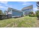 Back exterior featuring garage, fenced yard, screened in porch and barrels underneath small trees at 1814 Grovehurst Dr, Charleston, SC 29414