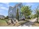 Side view of a blue home with manicured landscaping and a grassy yard next to a paved sidewalk at 1814 Grovehurst Dr, Charleston, SC 29414