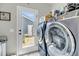 Well-equipped laundry room with modern washer and dryer units and outdoor access to the fenced yard at 1814 Grovehurst Dr, Charleston, SC 29414