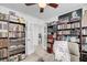 Inviting library featuring extensive bookshelves, a cozy recliner, French doors and view to another room at 1814 Grovehurst Dr, Charleston, SC 29414