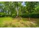 A tranquil backyard features a birdbath and garden bed among established trees and greenery at 206 Brailsford Rd, Summerville, SC 29485