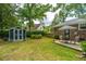A fenced backyard features a storage shed, patio seating and lush green grass at 206 Brailsford Rd, Summerville, SC 29485