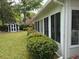 Exterior of the sunroom showing the backyard with lush bushes and a detached storage shed at 206 Brailsford Rd, Summerville, SC 29485