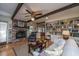 Cozy living room featuring a brick fireplace, hardwood floors, exposed beams, and built-in bookshelves at 206 Brailsford Rd, Summerville, SC 29485