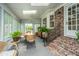 Enclosed sunroom with a brick accent wall and outdoor access, great for dining and enjoying the outdoors at 206 Brailsford Rd, Summerville, SC 29485