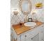 Charming bathroom with detailed wallpaper, wood countertop and white cabinet, and decorative lighting at 2114 Pettigrew St, Sullivans Island, SC 29482