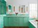 Bright bathroom with a double vanity, mint green cabinets, and stylish gold fixtures at 2114 Pettigrew St, Sullivans Island, SC 29482