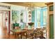 Open-concept dining room featuring wooden floors, an archway to kitchen, and turquoise window frames at 2114 Pettigrew St, Sullivans Island, SC 29482