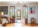 Charming entryway with wood floors, open wood-framed doors, and light-filled views of the outdoor garden at 2114 Pettigrew St, Sullivans Island, SC 29482