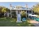 Charming two-story home with a screened porch, manicured lawn, swimming pool, and elegant landscaping at 2114 Pettigrew St, Sullivans Island, SC 29482