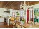 Bright kitchen featuring white cabinets, stainless steel appliances, and a wooden dining table with woven chairs at 2114 Pettigrew St, Sullivans Island, SC 29482