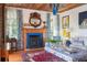 Cozy living room featuring a fireplace with blue tile, a wood mantel, and windows with patterned curtains at 2114 Pettigrew St, Sullivans Island, SC 29482