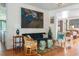 Bright living room with wood floors, a dark green sofa, light patterned chairs, and colorful decorations at 2114 Pettigrew St, Sullivans Island, SC 29482