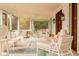 Covered outdoor porch with white wicker furniture for an outdoor entertaining space at 2114 Pettigrew St, Sullivans Island, SC 29482