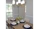 Dining room table setting with blue placemats, white napkins, and a modern chandelier at 212 Blue Heron Dr, Summerville, SC 29485