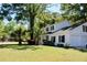 White two-story home with black shutters sits on a manicured lawn with mature trees adding shade at 212 Blue Heron Dr, Summerville, SC 29485