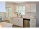 Bright kitchen features white cabinets, modern appliances, and a view to the backyard at 212 Blue Heron Dr, Summerville, SC 29485