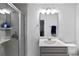 Well-lit bathroom featuring vanity with sink and mirror, chrome fixtures, gray tiled shower and floors at 2308 Watchtower Ln, Charleston, SC 29414