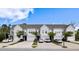 Beautiful townhomes feature single-car garages, dark front doors, manicured lawns, and landscaping at 2308 Watchtower Ln, Charleston, SC 29414