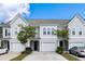 Beautiful townhomes feature single-car garages, dark front doors, manicured lawns, and beautiful landscaping at 2308 Watchtower Ln, Charleston, SC 29414