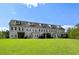 Three-story condo featuring multiple windows and covered patios overlooking a green lawn at 2308 Watchtower Ln, Charleston, SC 29414
