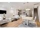 Open-concept living room featuring hardwood floors, white furniture, modern lighting, and staircase access at 2308 Watchtower Ln, Charleston, SC 29414
