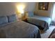 Well-lit bedroom showcasing two beds with blue patterned bedding and artwork on the wall at 237 Driftwood Ln, Edisto Island, SC 29438