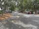 Paved street winding through a residential area with golf carts, cars, and trees at 237 Driftwood Ln, Edisto Island, SC 29438