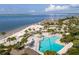 Aerial view of coastal resort with a sandy beach, pool, palm trees, ocean view, and clear skies at 2401 Racquet Club Dr, Seabrook Island, SC 29455