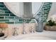 Close up of a beautifully tiled bathroom with a circular mirror and elegant chrome fixtures at 2401 Racquet Club Dr, Seabrook Island, SC 29455