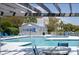 View of the pool surrounded by lounging chairs, landscaping, and building with pool rules at 2401 Racquet Club Dr, Seabrook Island, SC 29455