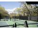 View of a tennis court with landscaping, benches, and shade umbrellas on a sunny day at 2401 Racquet Club Dr, Seabrook Island, SC 29455