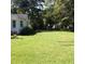 Spacious backyard featuring a lush green lawn and mature trees for shade at 32 Rosedale Dr, Charleston, SC 29407