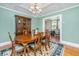 Elegant dining room with a wooden table, chandelier, and bright natural light, perfect for Gathering meals and entertaining at 32 Rosedale Dr, Charleston, SC 29407