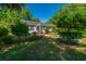 Beautiful single story home with manicured lawn, front yard with tropical plants and mature trees at 32 Rosedale Dr, Charleston, SC 29407
