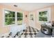 Bright eat-in kitchen with checkered floors, white door, and natural light from surrounding windows at 32 Rosedale Dr, Charleston, SC 29407
