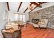 Spacious living room with wood beams, a brick fireplace, comfortable seating, and a large window for natural light, creating a cozy space at 32 Rosedale Dr, Charleston, SC 29407