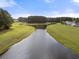 Expansive aerial view of a tranquil lake surrounded by lush greenery and a few houses at 321 Sanctuary Park Dr, Summerville, SC 29486
