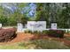 Landscaped Sanctuary Cove entrance sign with brick pillars and wrought iron fence at 321 Sanctuary Park Dr, Summerville, SC 29486