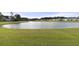 Lush green landscape featuring a tranquil pond, surrounded by grass and trees, with houses in the distance at 321 Sanctuary Park Dr, Summerville, SC 29486