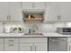 Bright kitchen featuring a decorative tile backsplash, stainless steel appliances, and white cabinets with bronze hardware at 3372 Billings St, Mount Pleasant, SC 29466