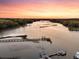 Beautiful aerial view of a river featuring serene water, docks and lush marsh grasses at sunset at 3610 Legareville Rd, Johns Island, SC 29455