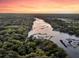 Sunset aerial view showcasing the tranquil river winding through lush green trees and marshland at 3610 Legareville Rd, Johns Island, SC 29455