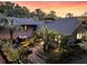 Exterior sunset view of backyard landscaping, deck with outdoor seating, and inviting fire pit at 3610 Legareville Rd, Johns Island, SC 29455