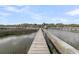 Scenic view of wooden dock extending over the marsh, leading to tranquil waters and distant landscapes at 3610 Legareville Rd, Johns Island, SC 29455