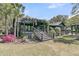 Charming home exterior with pergola-covered deck, lush landscaping, and serene outdoor space at 3610 Legareville Rd, Johns Island, SC 29455